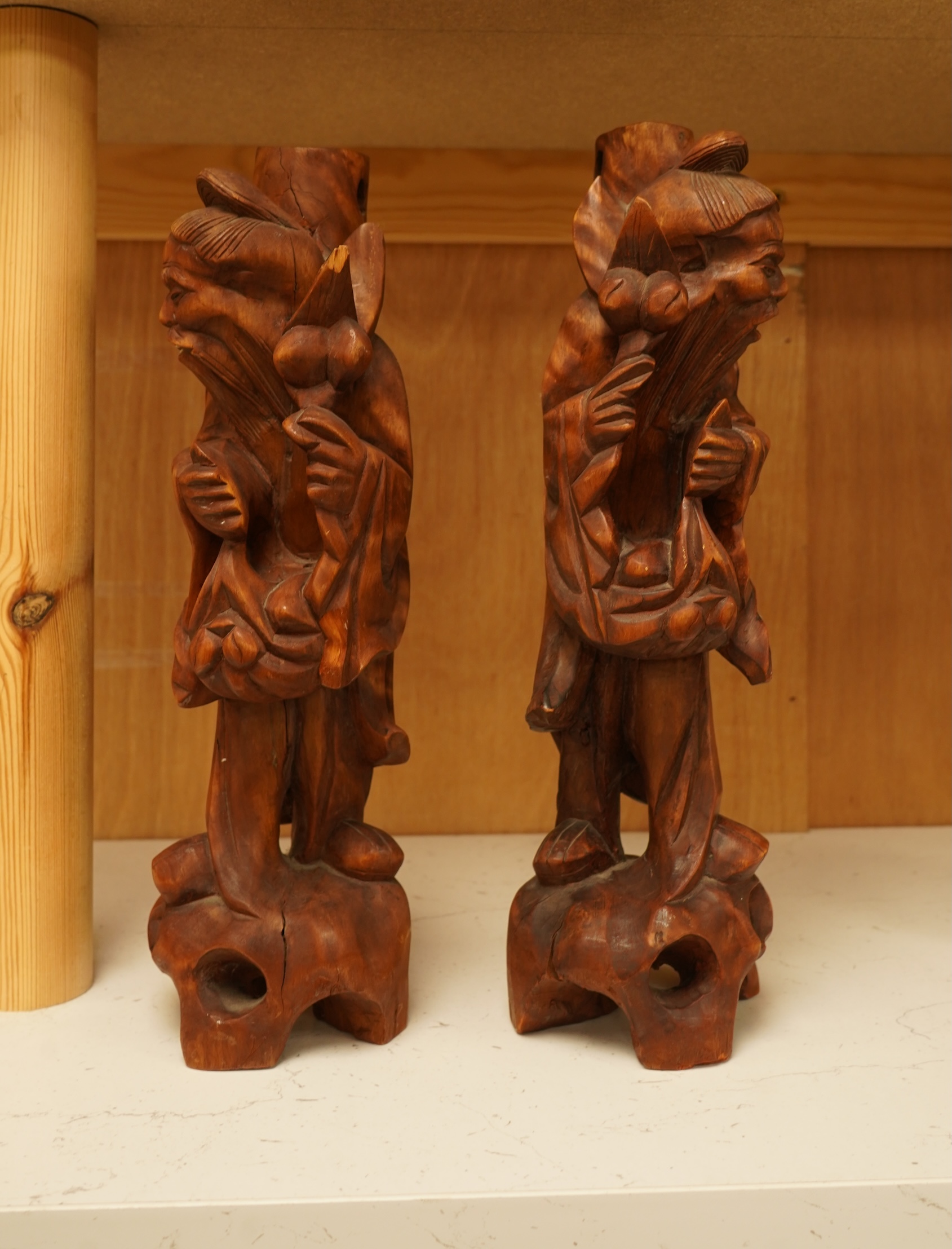 A pair of 20th century Chinese carved wood figures of sages, 31cm